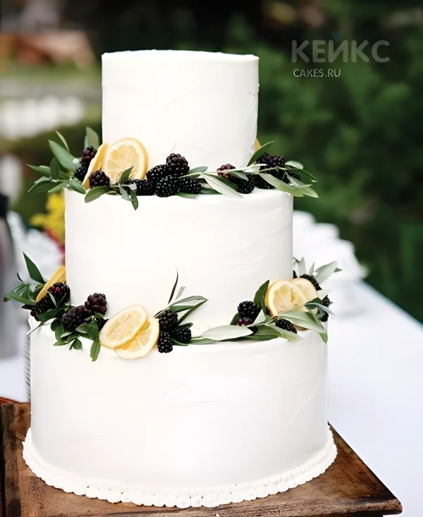 Белый свадебный торт с фруктами украшенный лимонами и ежевикой Фото