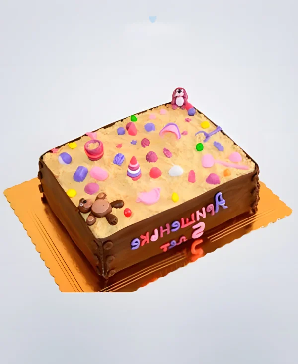 Торт в виде большой песочницы с розовыми игрушками Фото