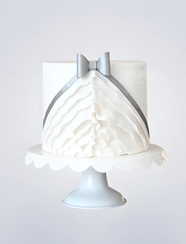 Торт в виде белого платья с рюшами и бантиком Фото