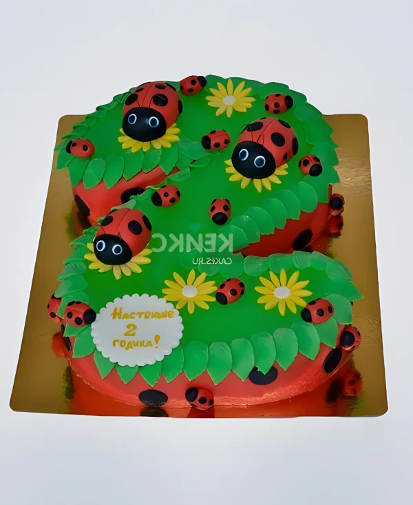Яркий торт с божьими коровками на лужайке Фото
