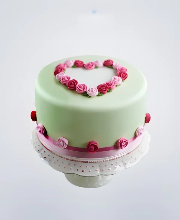 Зеленый торт украшенный розами в форме сердца Фото