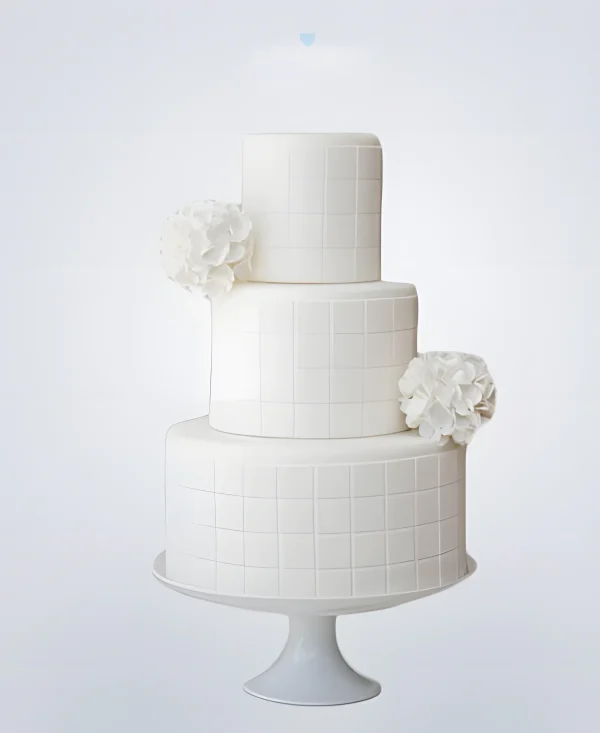 Белый трехъярусный недорогой свадебный торт с квадратами и цветами Фото