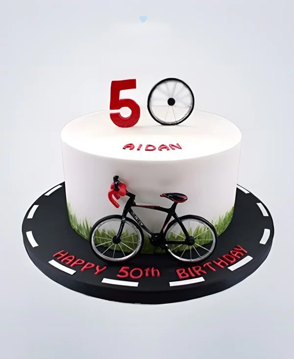 Торт белого цвета с велосипедом и дорогой Фото