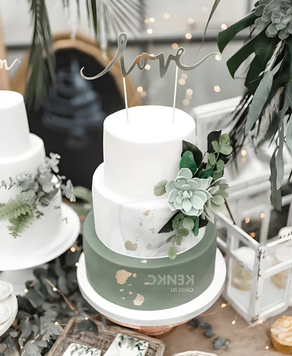 Свадебный торт зеленый, украшен золотом и зеленым цветком Фото