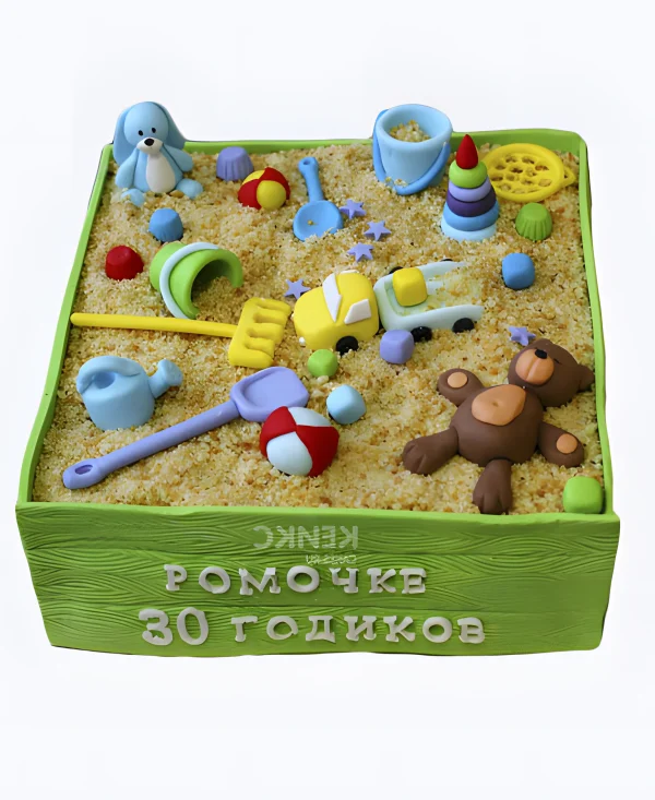 Зеленый торт в виде песочницы с игрушками Фото