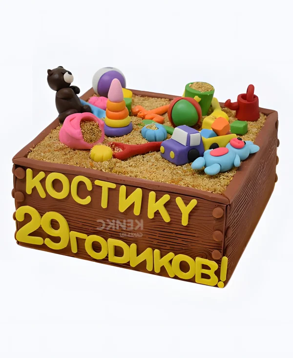 Торт в виде коричневой песочницы с желтой надписью Фото