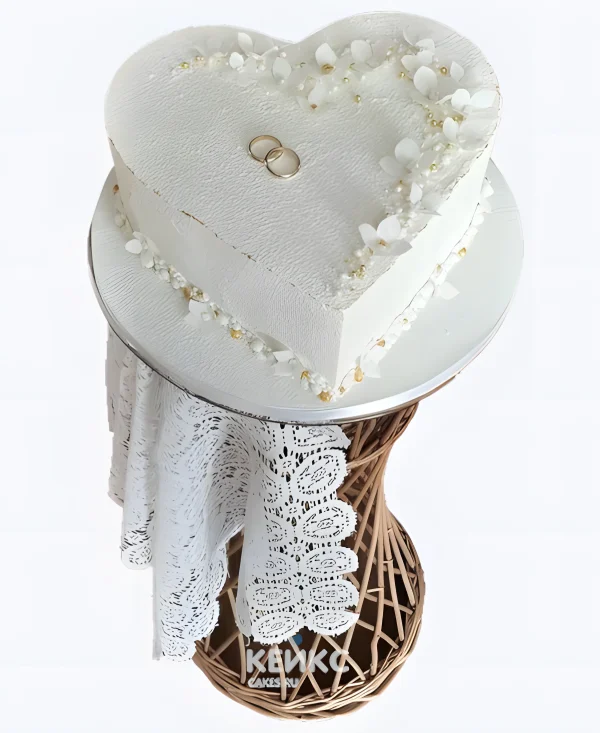 Нежный свадебный торт в виде сердца с золотыми кольцами Фото