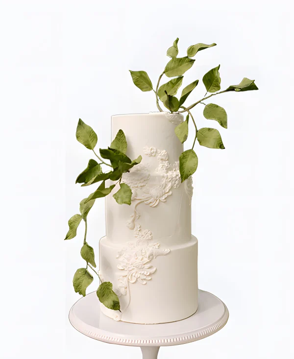 Трендовый торт на свадьбу с узорами и зелеными листьями Фото